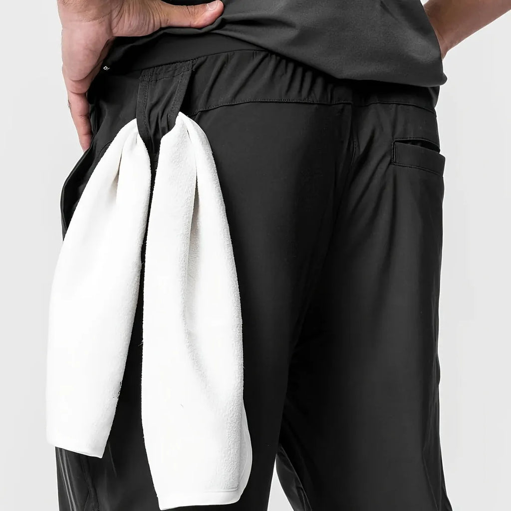 Men's solid colour polyester jogger pants in black, mid-waist micro-elasticity sports trousers for autumn leisure.