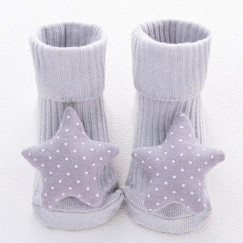 Cotton baby floor socks in various colours and patterns including pink bows, grey stars, and panda design.
