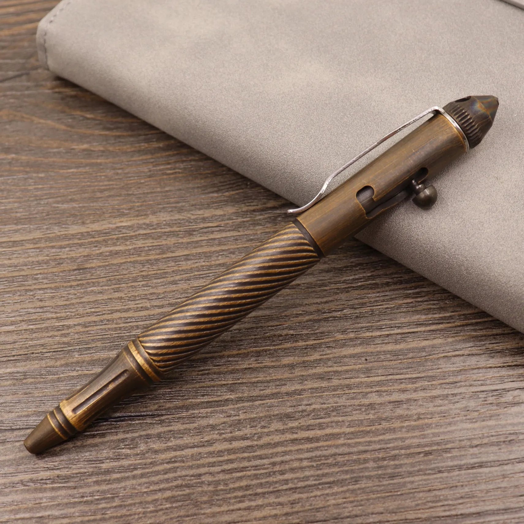 Brass bolt-action tactical pen with cylindrical barrel and press mechanism in retro finish
