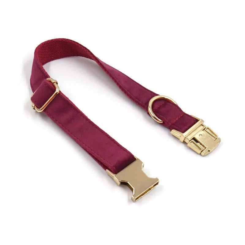 Burgundy velvet dog collar set with bow tie and leash on a wooden floor