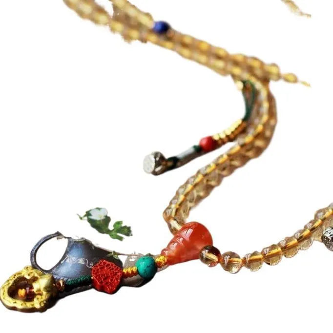 Close-up of a yellow Brazilian citrine bracelet with small 1mm beads on a black filament cord.