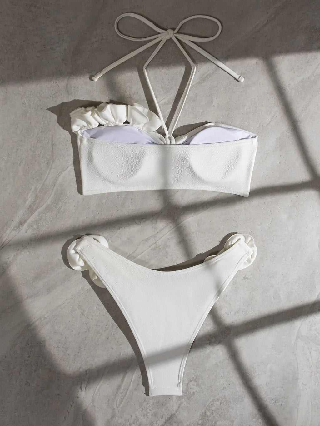 White women's swimsuit with 3D floral pattern, halter neck, and lace-up back.