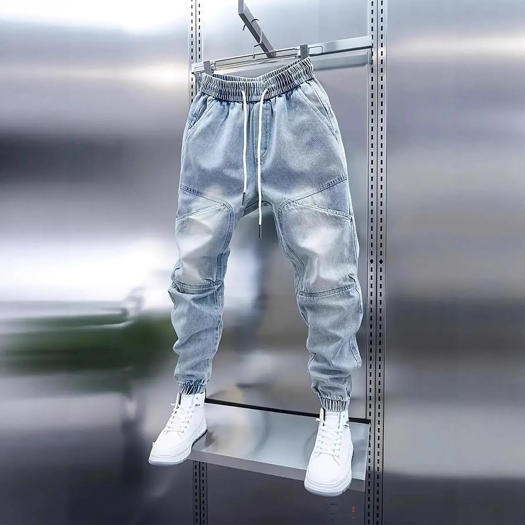 Men's light blue micro-elastic cotton denim pencil trousers with drawstring waist and elastic ankle bands on a model.