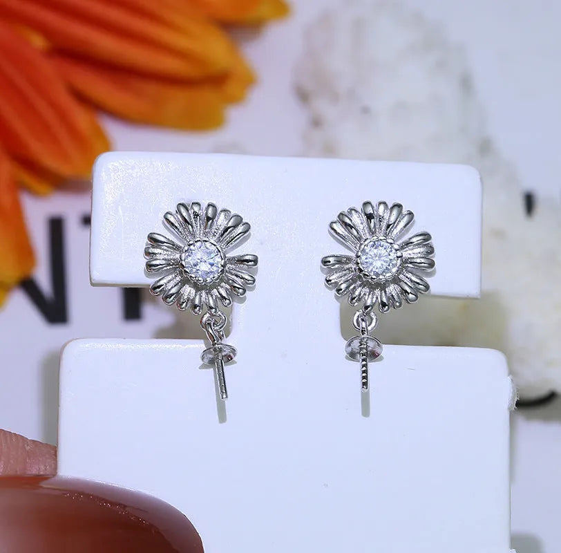 Baroque-style sterling silver flower earrings with an integrated ring holder loop on a white background.