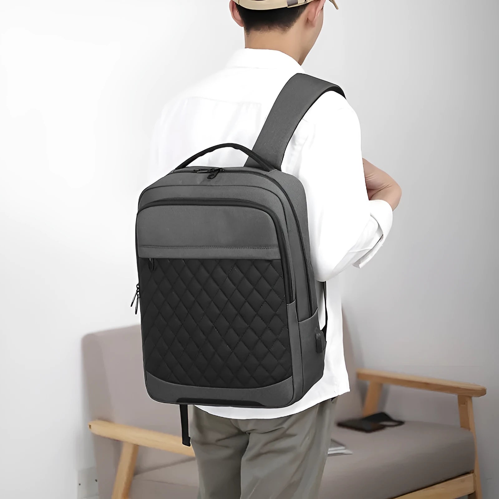 Men's Oxford cloth travel backpack in black with curved shoulder strap and diamond mesh detail