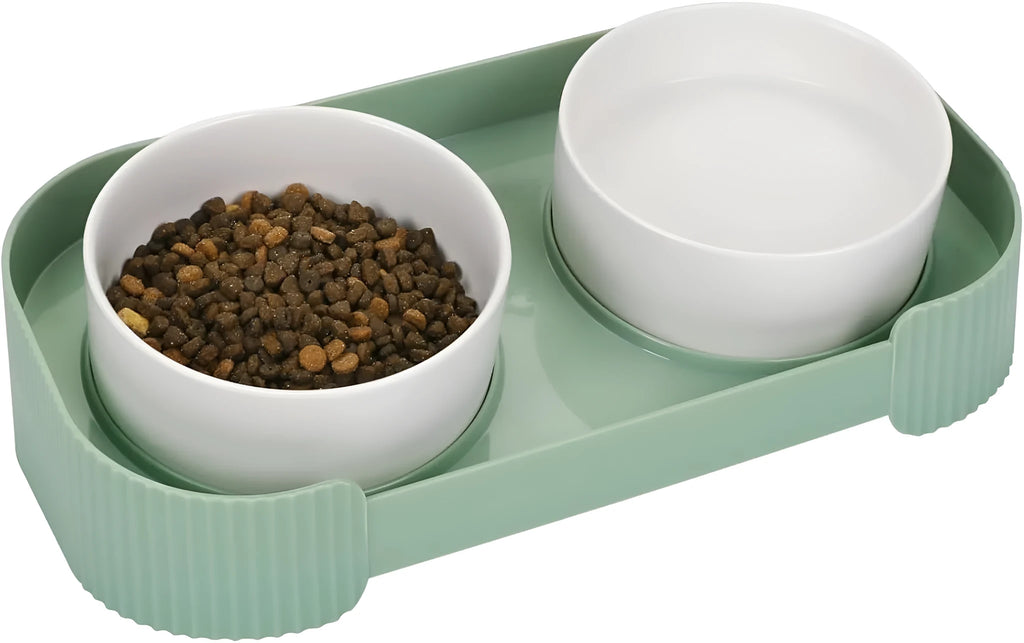 Green ceramic raised cat bowl set with two bowls on a tilted stand, showing non-slip base.