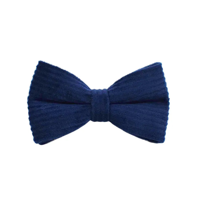 Navy blue corduroy dog collar and leash five-piece set with bow, vest, and poop bag on a wooden floor