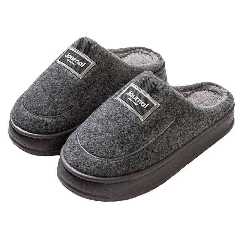 Men's brown and grey suede slippers with a thick sole on a plain background