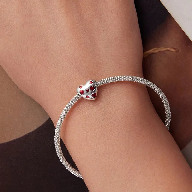 Red heart-shaped S925 sterling silver bead with glossy drip oil finish on plain background