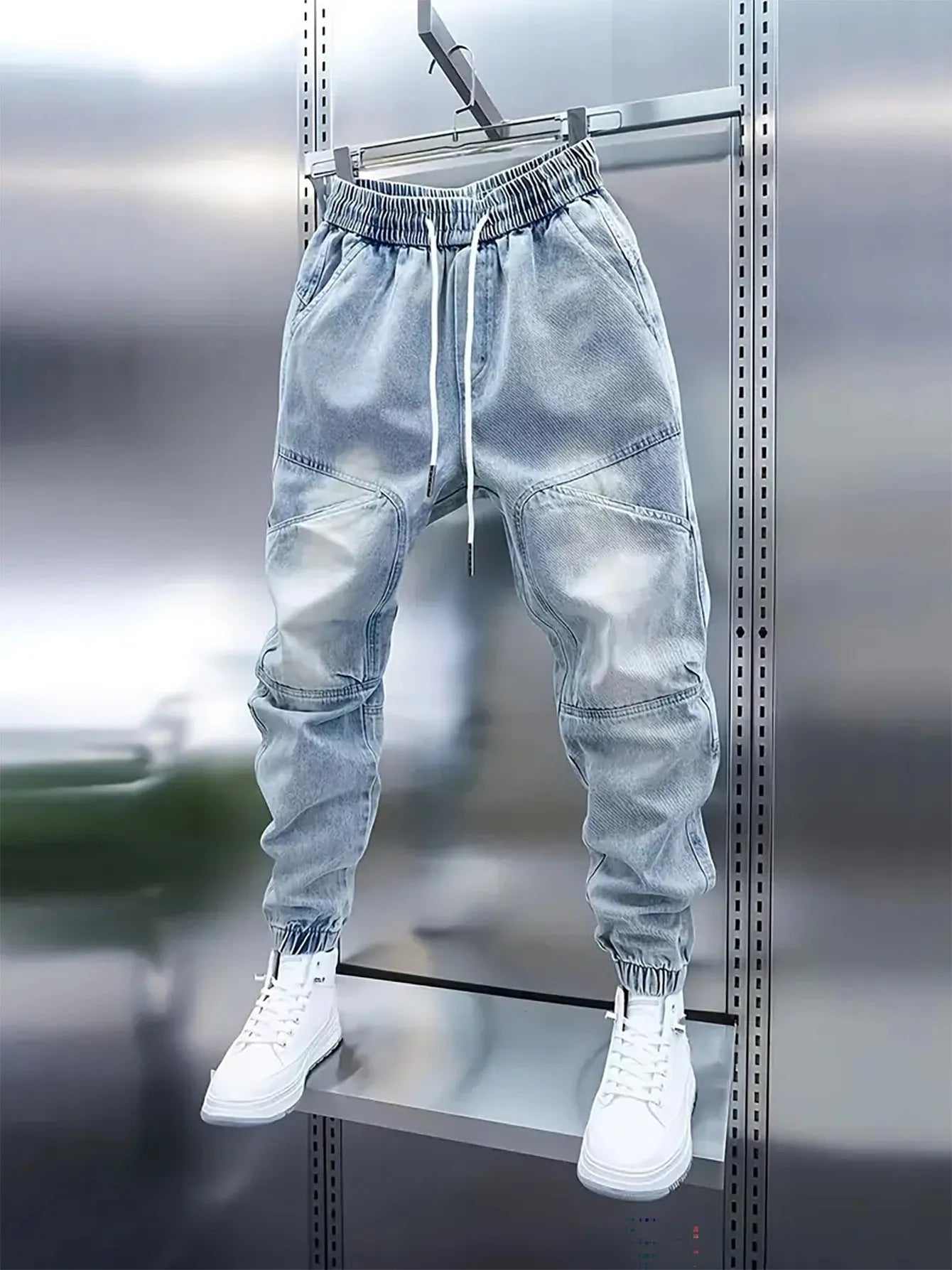 Men's light blue micro-elastic cotton denim pencil trousers with drawstring waist and elastic ankle bands on a model.