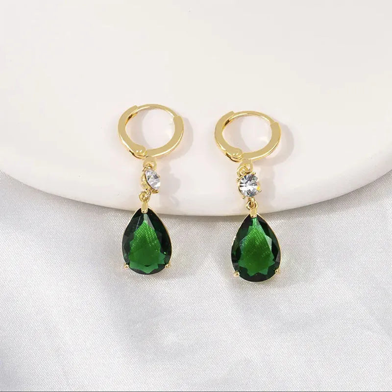 Pair of green geometric teardrop-shaped alloy earrings on a white background.
