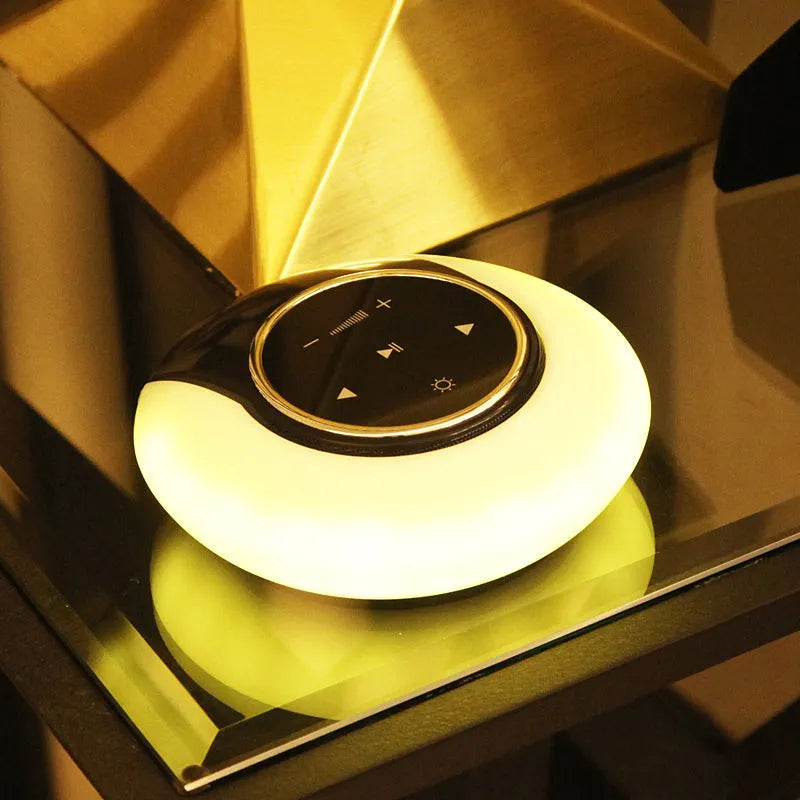 Folding Bluetooth desk lamp and speaker with touch controls showing blue atmospheric LED light.
