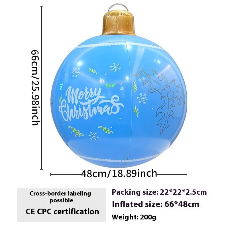 Large red inflatable Christmas ball with snowflake design and flashing lights in a garden setting.