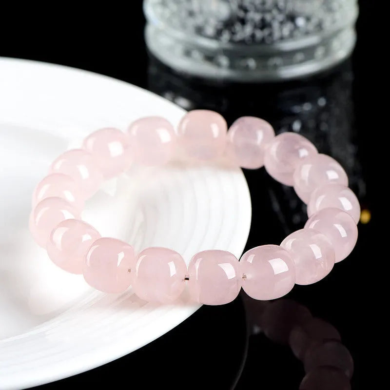 Pink crystal barrel bead bracelet on a black adjustable cord, showing geometric design.