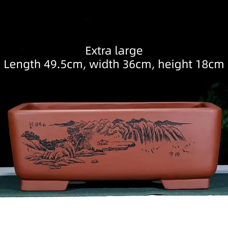 A deep blue black handmade rectangular purple clay bonsai pot on a wooden surface.