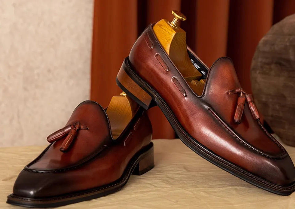 Men's black genuine leather loafers with a fringed detail and slip-on design.