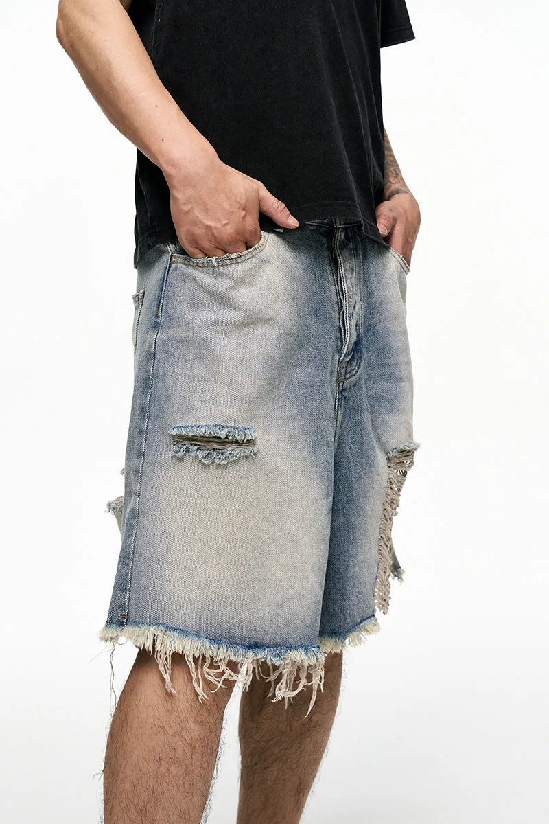 Light blue washed denim shorts for men with a baggy fit and mid waist, shown on a hanger.