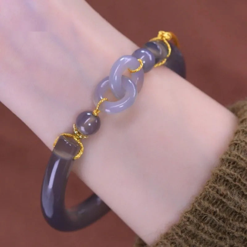 Grey smoke purple agate bead bracelet with metal ring buckle closure on a wrist.