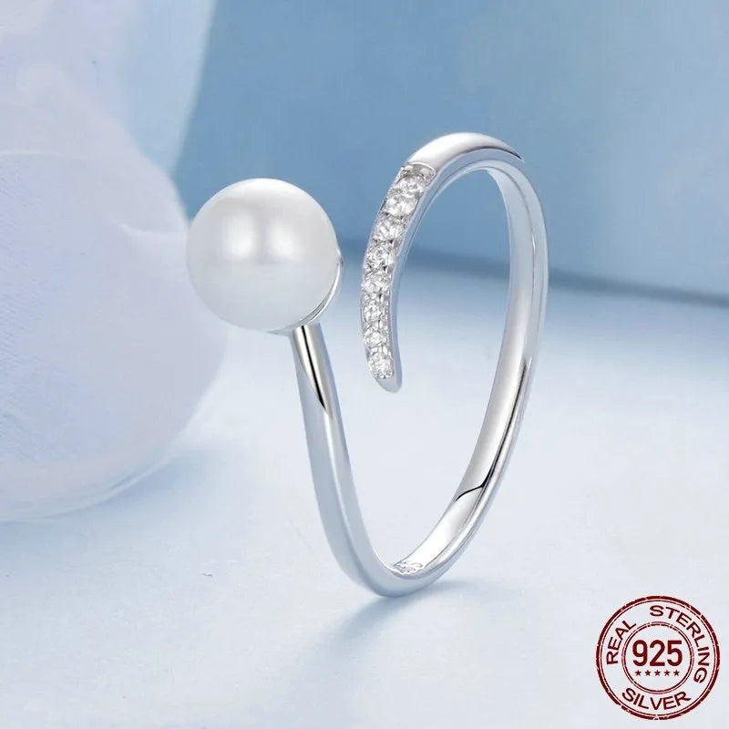Close-up of an adjustable S925 sterling silver ring featuring a natural shell pearl on an open loop band.