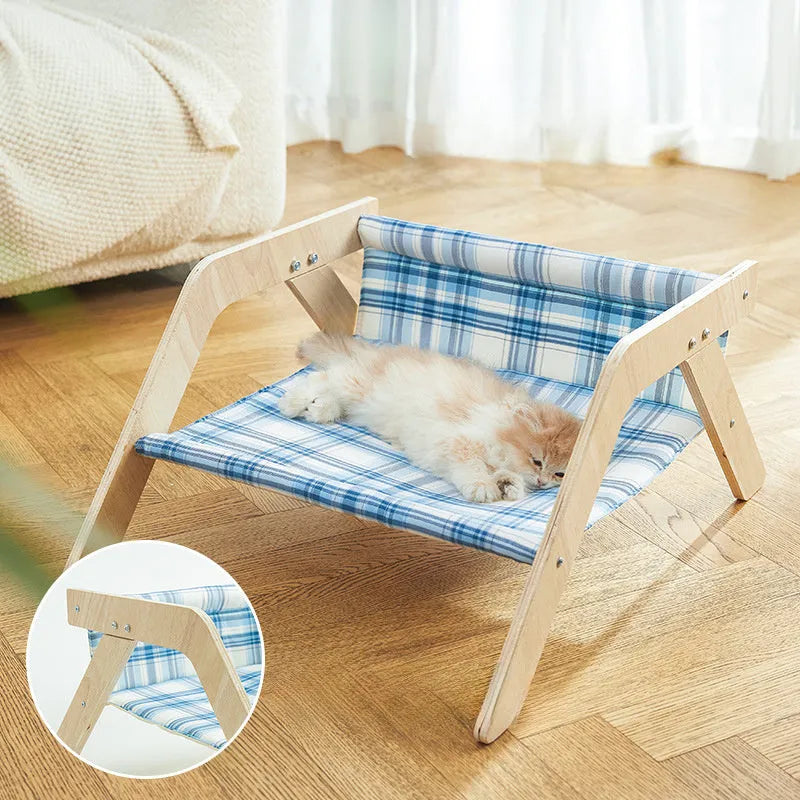 Wooden elevated cat bed with blue cloth hammock suspended inside frame