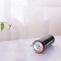 Black wireless portable humidifier with colourful lights beside car cup holder
