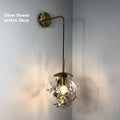 Modern creative wall-mounted bedside lamp with a golden flower glass shade and warm LED light.