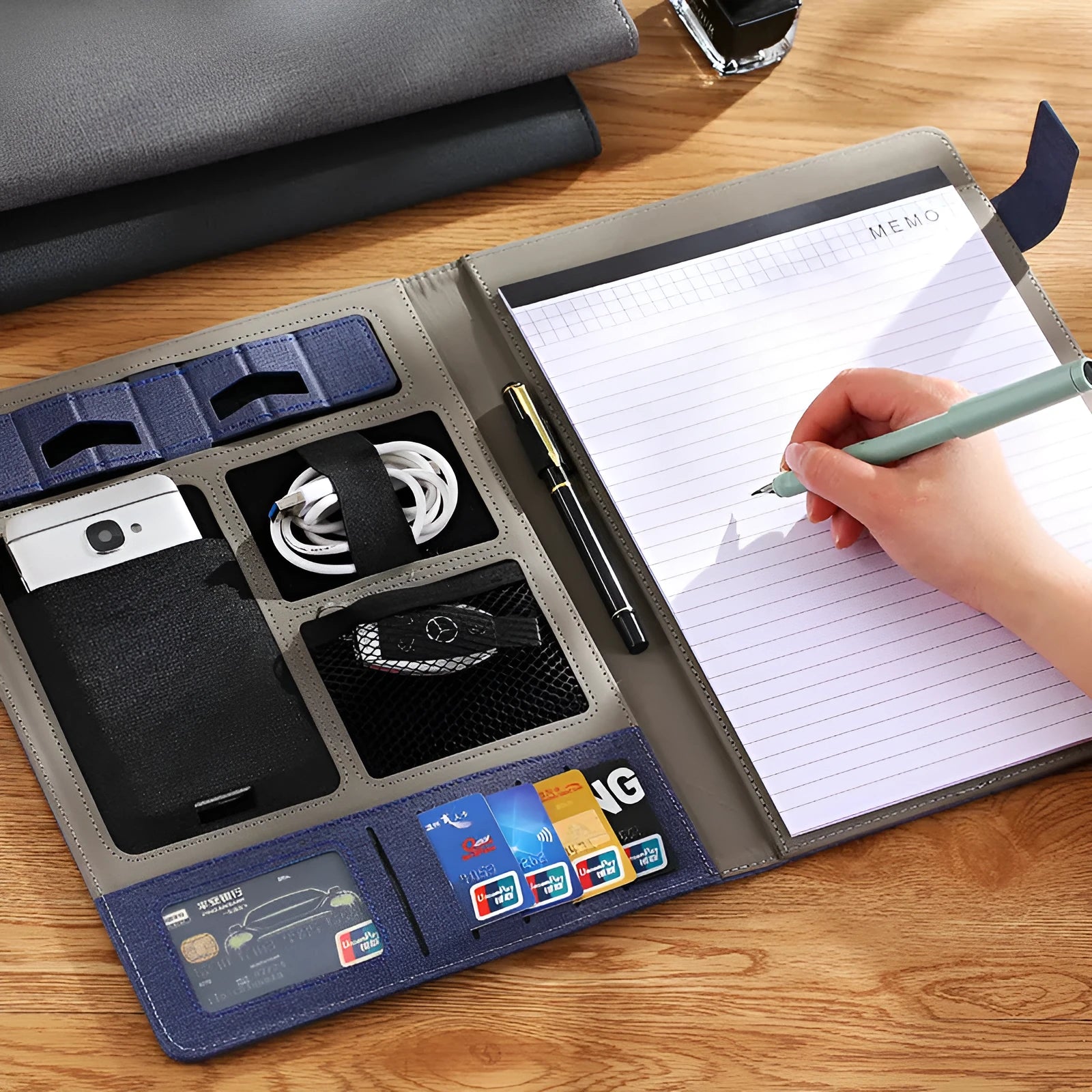 Black leather A4 document folder with pen loop and attached notepad, showing business organiser.