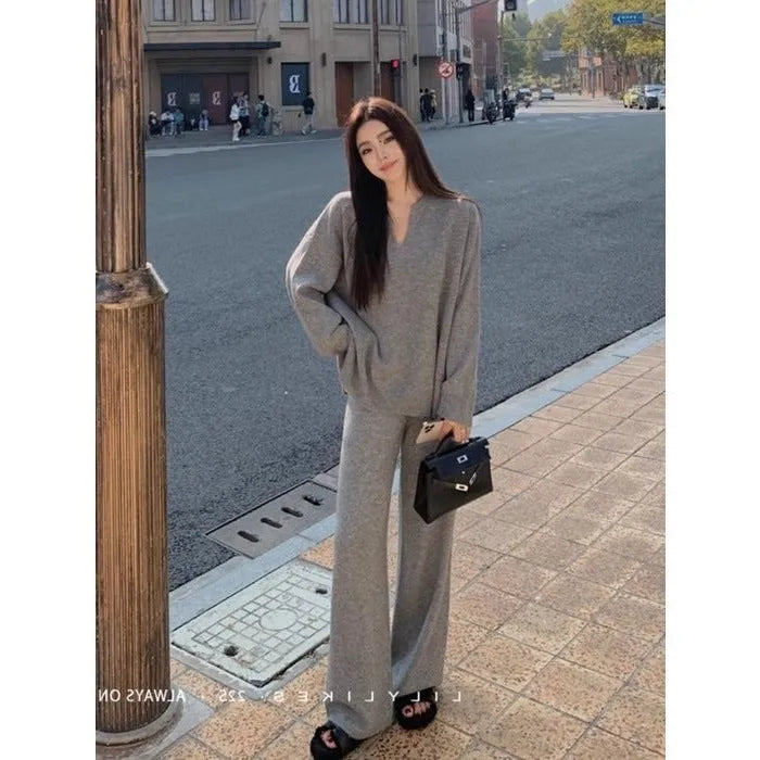 Women's V-neck knitted two-piece suit with wide-leg pants in beige, showing asymmetric pleating on top
