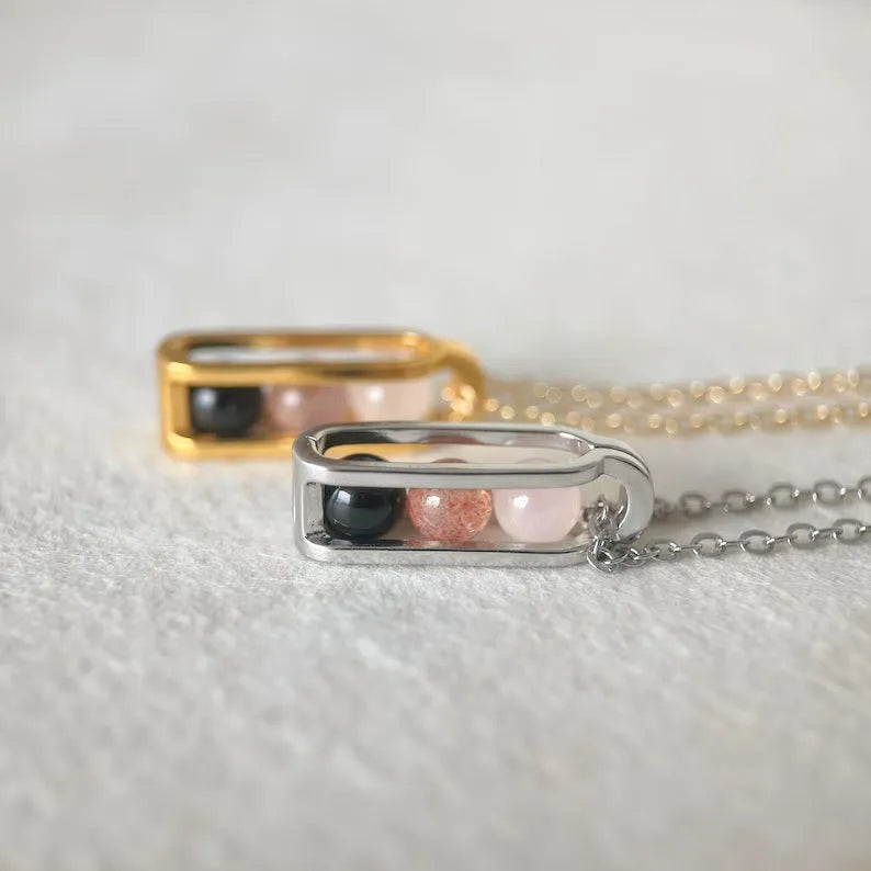 Minority simple pearl necklace with gold titanium steel chain and inlaid pearl pendant on plain background