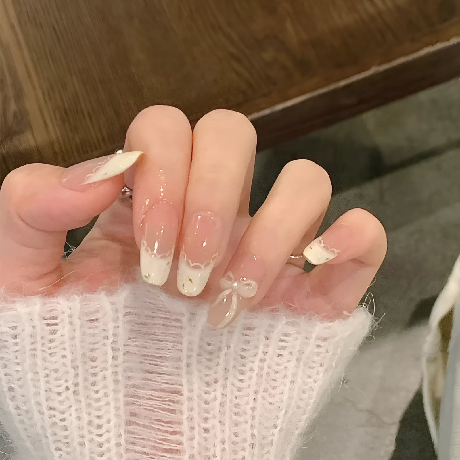 Assortment of sweet girl style false nails in various colours and designs, laid out on a table.