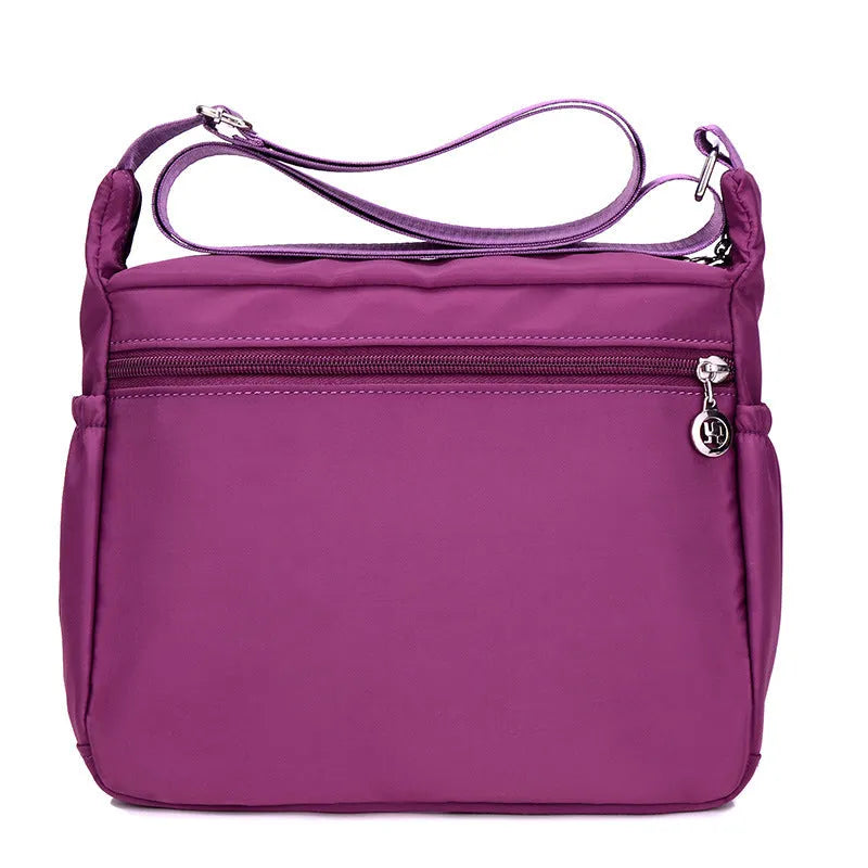 Lightweight nylon women's one shoulder crossbody bag in black with horizontal square shape and visible sewing thread detail