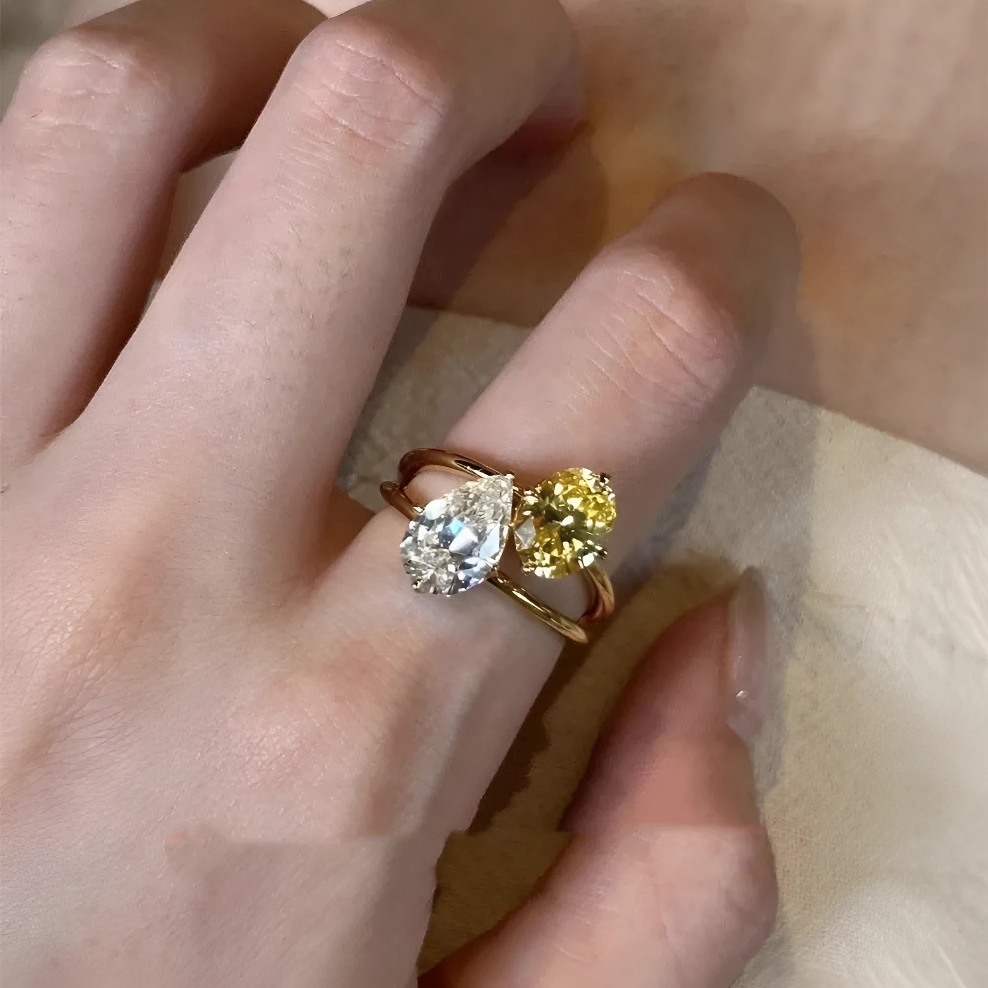Geometric copper open ring for women with a water drop shape and double Sheng zircon stone setting.