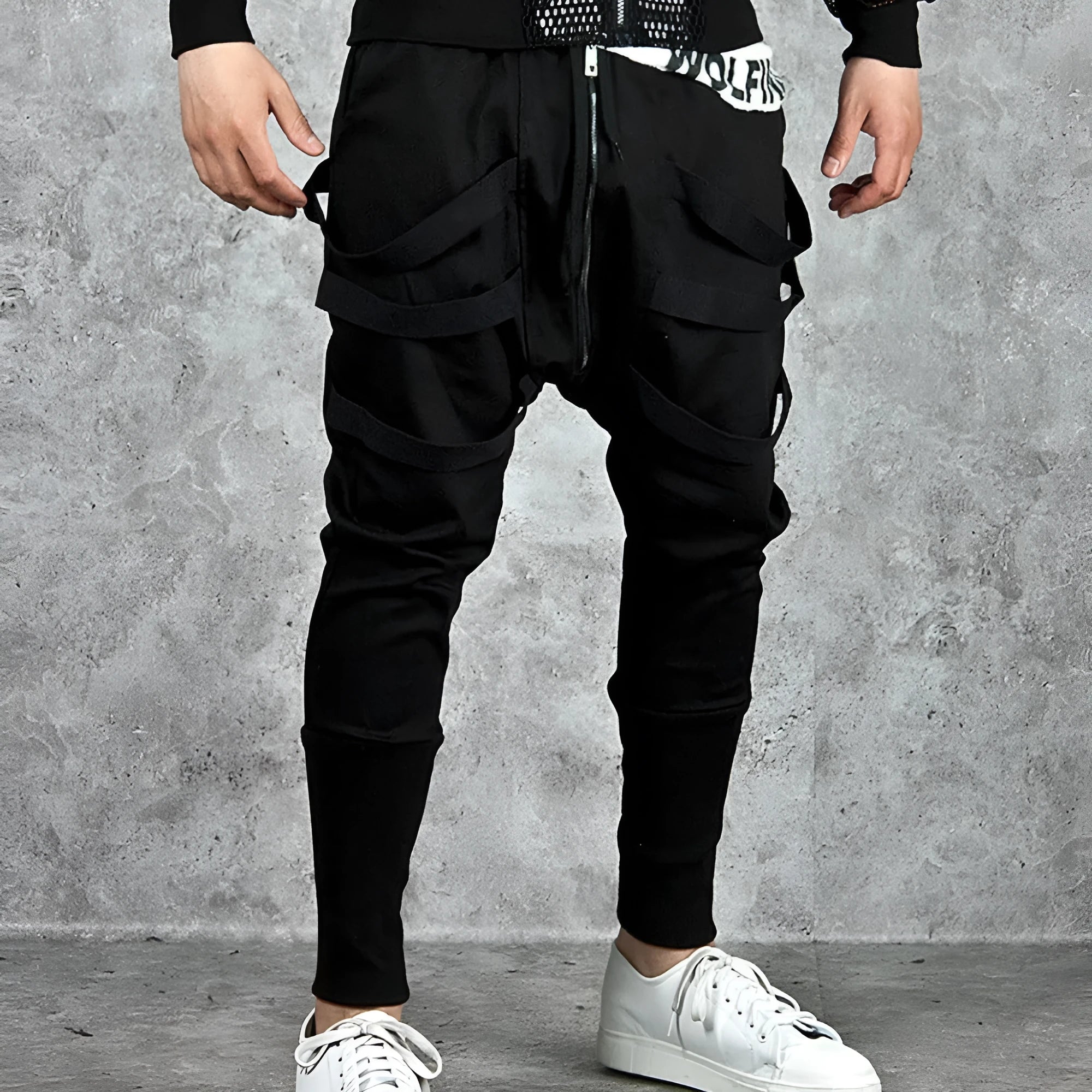Men's black low crotch cross trousers with tapered cone leg and small hem on a plain background
