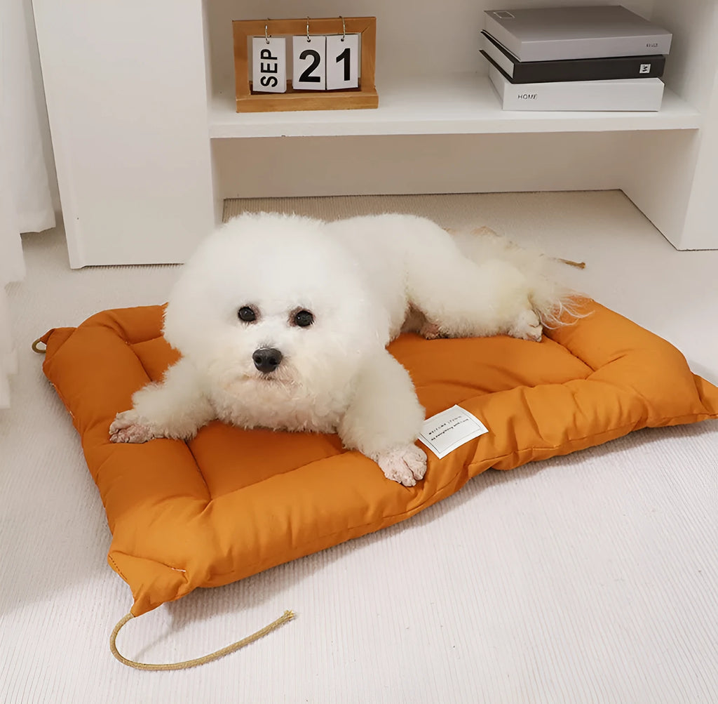 Beige tied cage cushion for small dog in crate showing secure attachment and warm bedding platform.