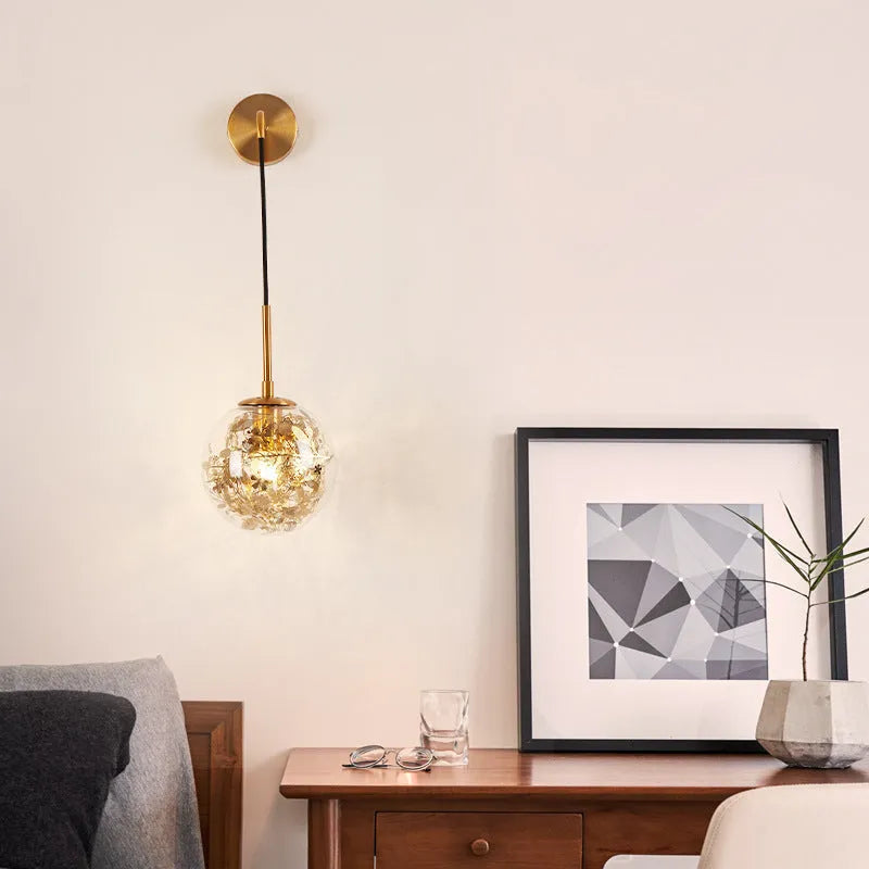 Modern creative wall-mounted bedside lamp with a golden flower glass shade and warm LED light.