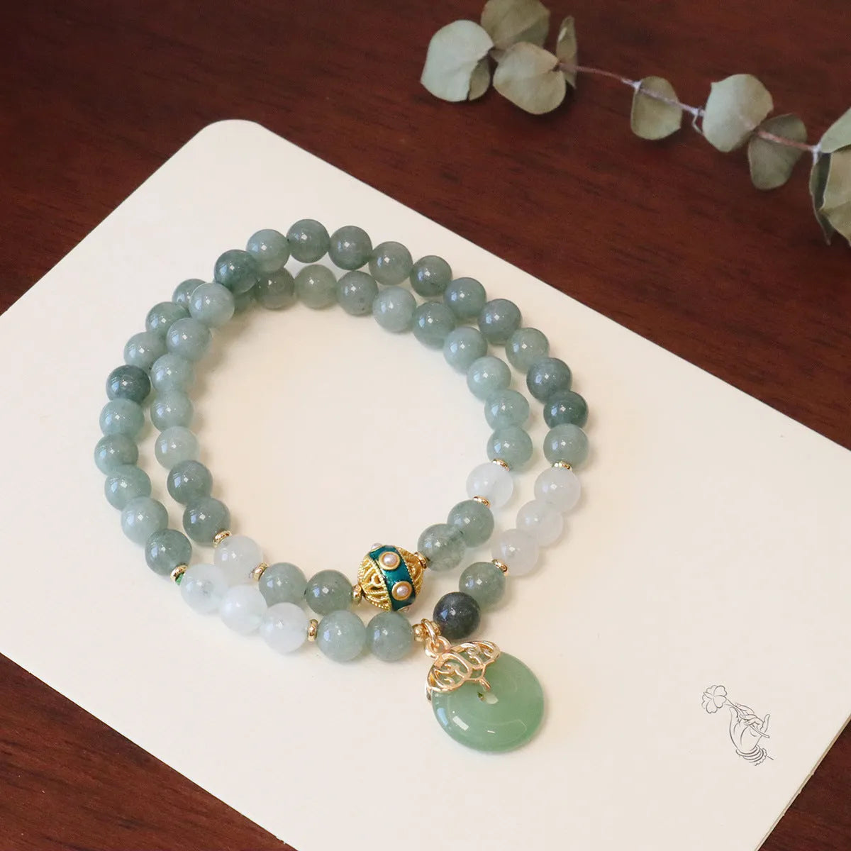 Close-up of a women's Myanmar jade bracelet with a safety buckle pendant, crystal, and geometric lucky beads in a new Chinese style.