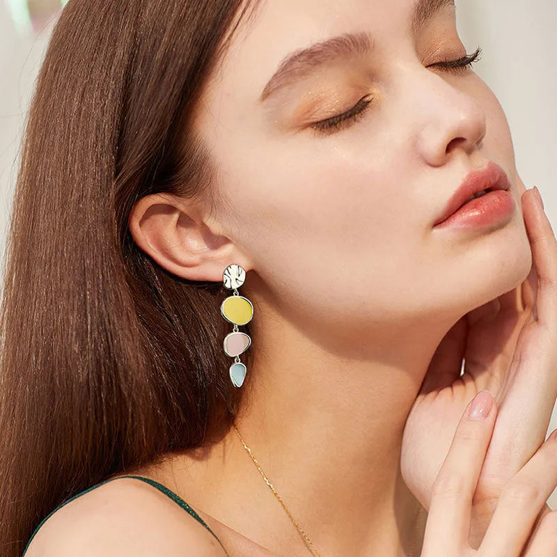 A pair of simple disc-shaped earrings with a morandi three-colour oil-drip finish and sterling silver posts.
