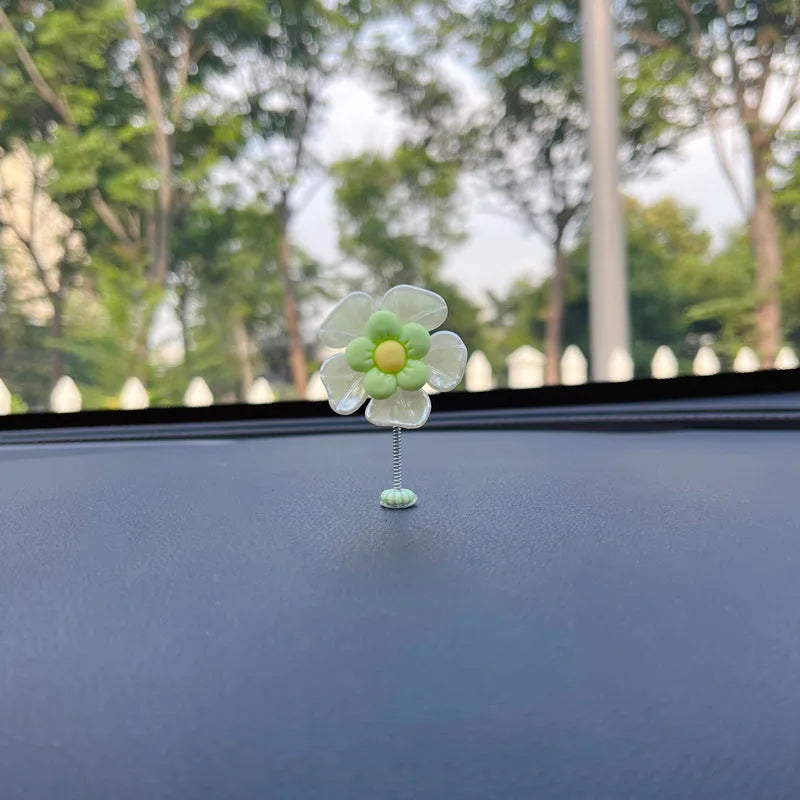 Small blue plastic swing ornament for car dashboard, 5cm tall on a grey surface.