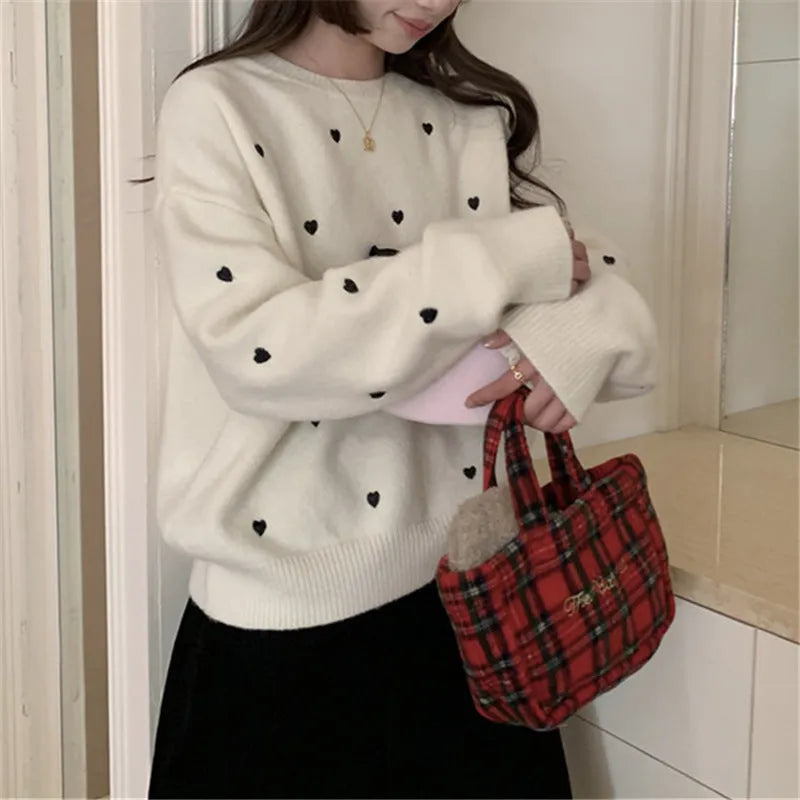 Women's loose beige acrylic pullover sweater with embroidered red love heart design on the chest.