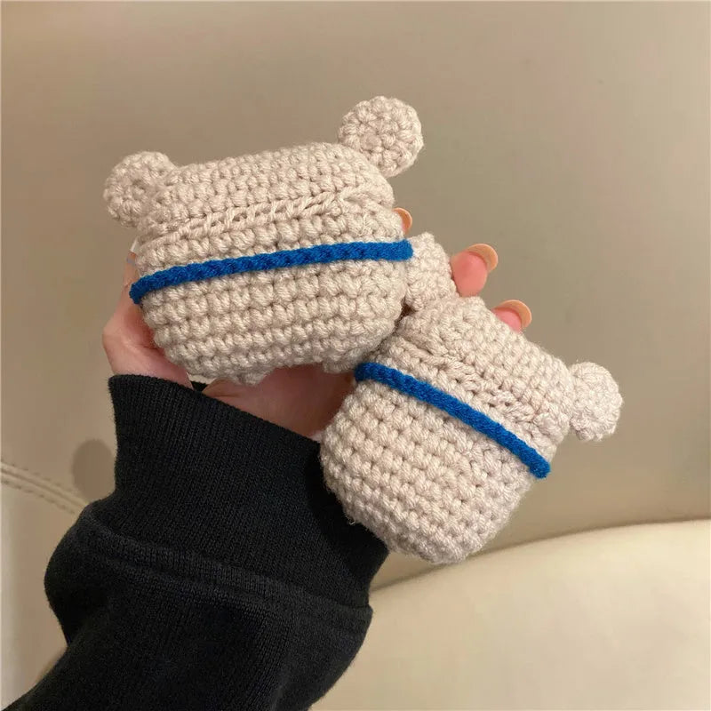 Handmade knitted AirPods case shaped like a backpack with koala ears on a blue background.