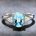 A women's court style ring with a natural blue zircon stone set in a heart-shaped pattern.