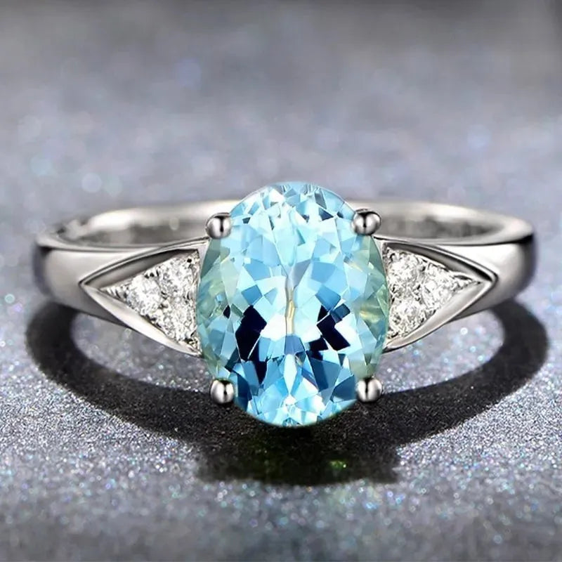 A women's court style ring with a natural blue zircon stone set in a heart-shaped pattern.