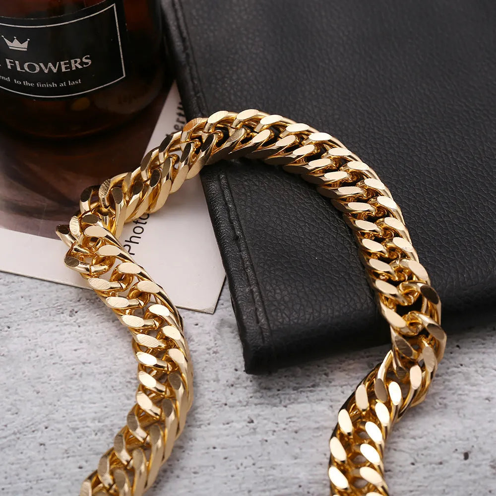 Gold electroplated women's necklace with thick chain and teardrop pendant on a grey background.