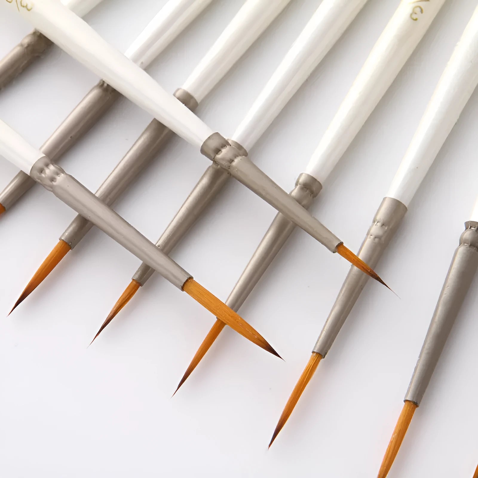 Set of 12 pearl white artists' brushes in a solid wood holder, sizes from 0 to 4/0 for watercolour and acrylic painting.