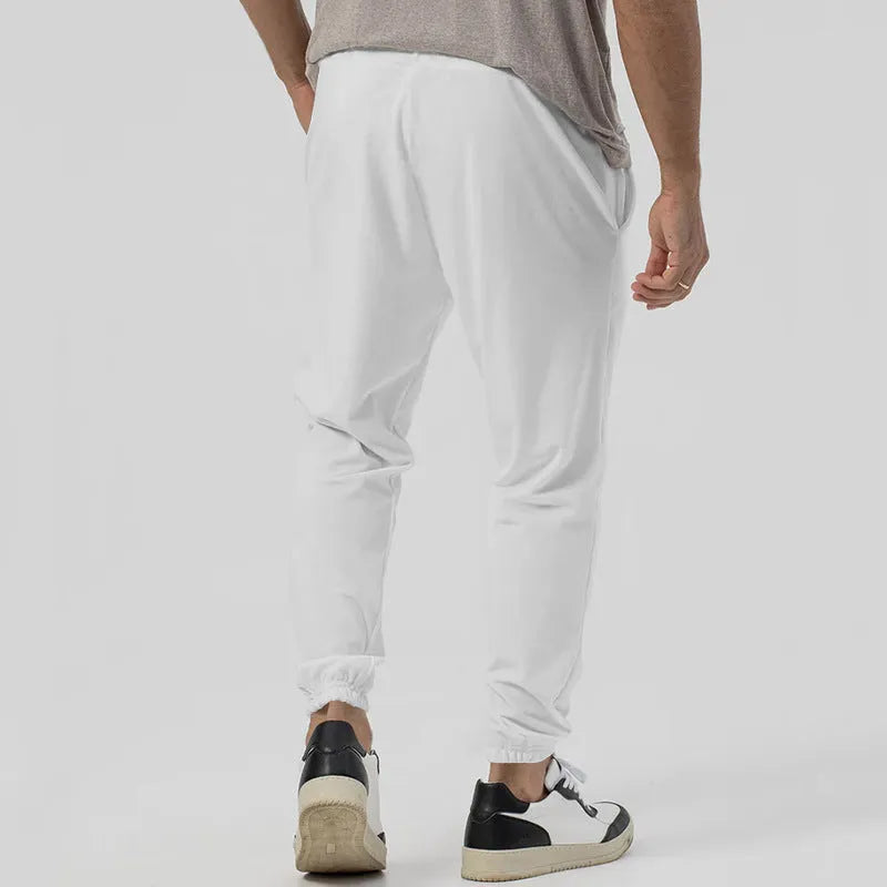 Men's grey straight-leg track sweatpants with a mid-waist, showcasing a relaxed fit and casual style.