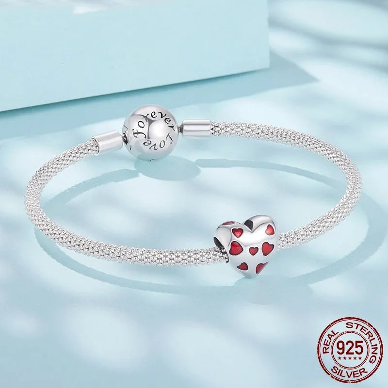 Red heart-shaped S925 sterling silver bead with glossy drip oil finish on plain background