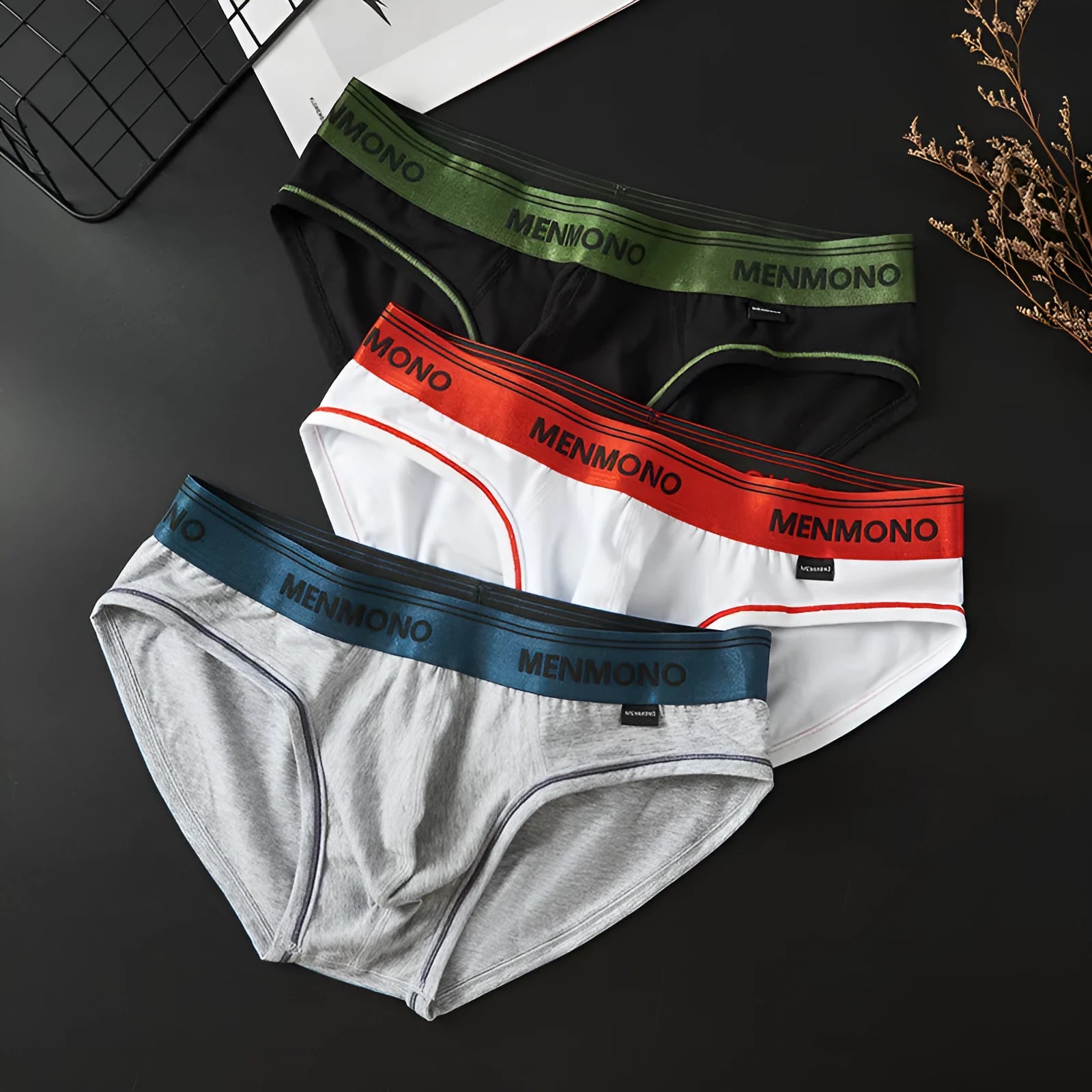 Men's low-waist cotton briefs in a colour-block design on a size chart.