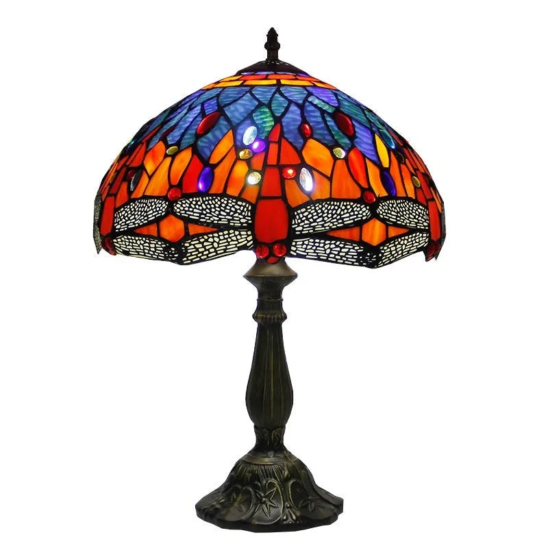 Tiffany-style stone table lamp with blue dragonfly design on a wooden surface.