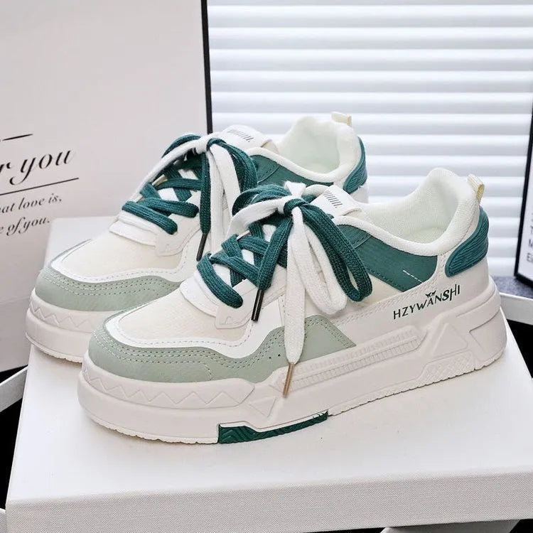 Children's beige platform trainers with cross-strap design over laces and a thick rubber sole.