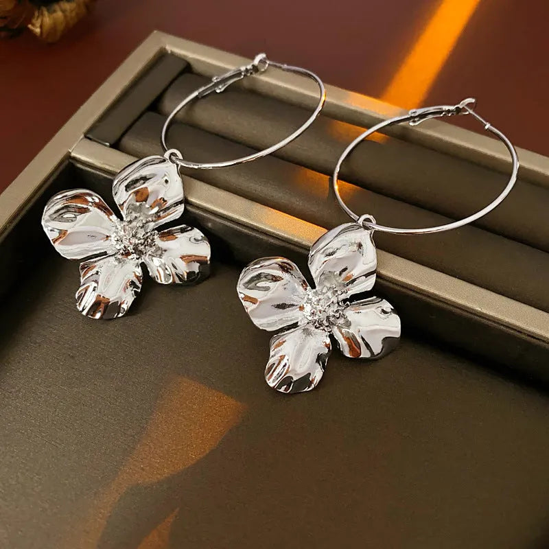 Geometric flower-shaped alloy earrings with a gold or silver electroplated finish.